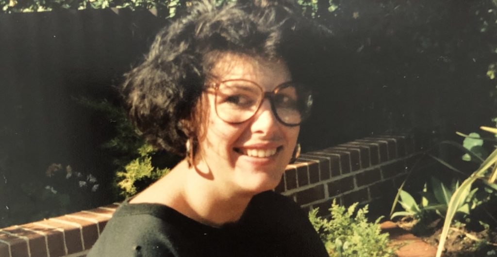 Close up of Jacinta smiling at camera after her accident, wearing glasses